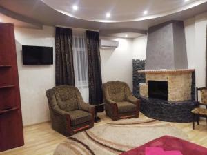 a living room with two chairs and a fireplace at Панський Двір in Neslukhov +47 photos