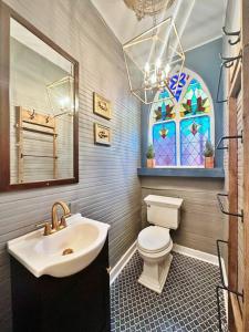 a bathroom with a sink and a toilet and a window at The Q Loft Galveston in Galveston