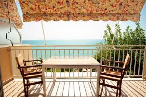 a table and two chairs on a balcony with the ocean at Rosa's Beach Studios in Lourdata