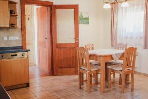 - une cuisine avec une table, des chaises, une table et une porte dans l'établissement Krásný srub na jihu Brna, à Želešice