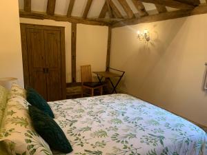 a bedroom with a bed and a table in a room at NEW Cosy cottage - Lake view & Log Burner - Dog proof garden in Rolvenden