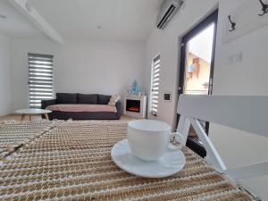 eine Kaffeetasse auf einem Bett im Wohnzimmer in der Unterkunft La Casuță in Dej