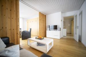 una sala de estar con una mesa de centro blanca en una habitación en Feriensiedlung Trü 9 en Scuol