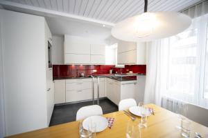 a kitchen with a wooden table and white cabinets at Feriensiedlung Trü 9 in Scuol