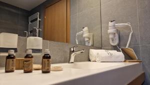 布拉索夫的住宿－Hotel Sorin MIHAI，一间带水槽和镜子的浴室