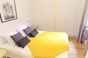 una camera con un letto con una coperta gialla di Belle Vue - Appartement 2 chambres avec parking a Bordeaux