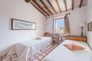 a bedroom with two beds and a window at Appartamento La Scaletta in Capoliveri