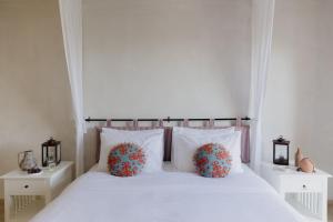um quarto com uma cama branca com duas almofadas em Village Heights Resort em Hersonissos