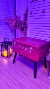 a red bench sitting in a room with a candle at Ginko sobe Daruvar in Daruvar