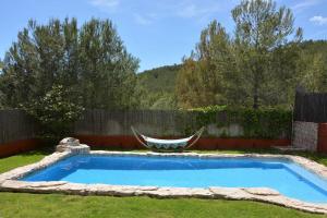 een zwembad met een hangmat in de tuin bij Villa Sitges El Olivo High Comodity AC Pool Heated Optional Real Garden Pool XXL in Olivella