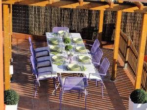 a table with purple chairs and plates on a deck at Villa Sitges El Olivo High Comodity AC Pool Heated 30º Optional Real Garden Pool XXL 10 min drive from Sitges in Olivella