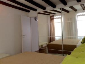 1 dormitorio con cama y espejo en una habitación en Nel Cuore Di Venezia, en Venecia