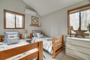two twin beds in a room with two windows at Peaceful Pocono Pines Getaway Hot Tub and Fire Pit! in Pocono Pines
