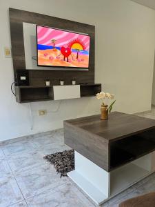 sala de estar con TV en la pared en Departamento temporario Zona Centro en La Plata
