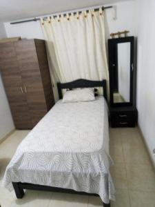a bedroom with a bed with a mirror and a dresser at Apartamento vía a Minca in Santa Marta