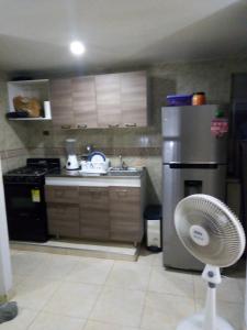 a kitchen with a refrigerator and a fan in it at Apartamento vía a Minca in Santa Marta
