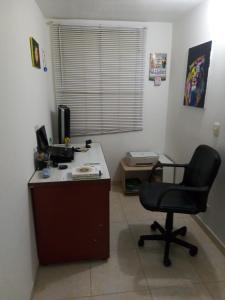 an office with a desk with a chair and a computer at Apartamento vía a Minca in Santa Marta