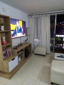 a living room with a flat screen tv and a couch at Apartamento vía a Minca in Santa Marta