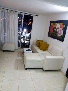 a living room with a white couch and a window at Apartamento vía a Minca in Santa Marta