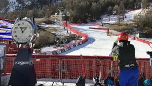 a person standing next to a clock on a ski slope at Residence & Spa Les Chalets de Solaise in Val dʼIsère