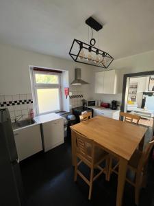 a kitchen with a wooden table and a dining room at La petite maison in Houyet