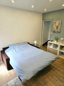 een groot bed in een kamer met een houten vloer bij Maison rénovée proximité de paris 20eme in Bagnolet