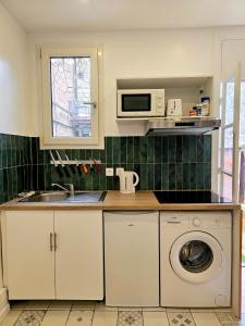 een keuken met een wasmachine en een magnetron bij Maison rénovée proximité de paris 20eme in Bagnolet