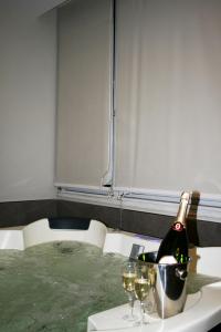 una bottiglia di champagne seduta su un tavolo con bicchieri da vino di Angel's Paradise a Mariglianella