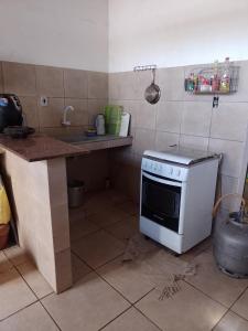 uma cozinha com um balcão e um fogão em Casa na praia Fagundes/Lucena 
