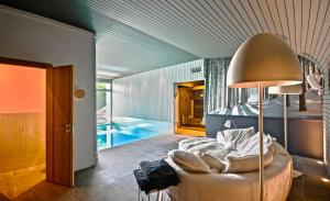 een woonkamer met een bank en een zwembad bij Sumptuous Chalet with Breathtaking views by GuestLee in Gryon