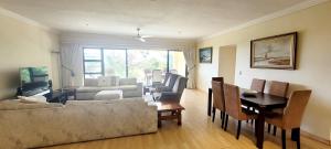 a living room with a couch and a table at Shelly Beach beachfront apartment in Shelly Beach