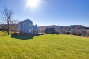 a blue house in a field of green grass at Cozy Illinois Abode with Deck and Grill, Near Golfing! in Galena