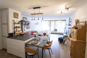 a kitchen and living room with a table and chairs at Chasa Tulai F114 in Scuol