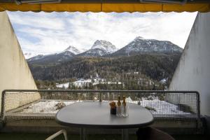 a table on a balcony with a view of mountains at Chasa Tulai F114 in Scuol