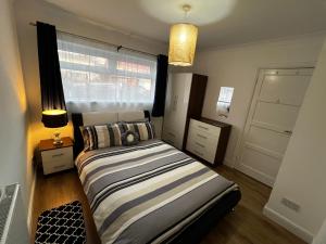 um quarto com uma cama e uma janela em Springfield House- Near Newcastle Centre, Hospital and Keele University! em Stoke-on-Trent