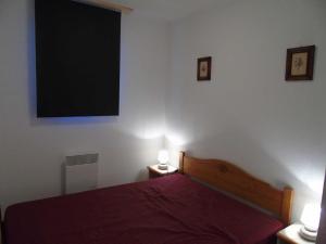 een slaapkamer met een bed en een flatscreen-tv bij Appartement Valfréjus, 4 pièces, 8 personnes - FR-1-561-45 in Valfréjus