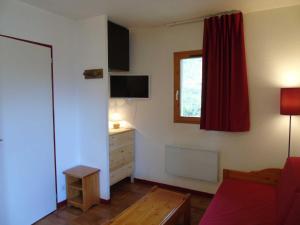 a living room with a dresser and a red curtain at Appartement Valfréjus, 2 pièces, 4 personnes - FR-1-561-6 in Valfréjus
