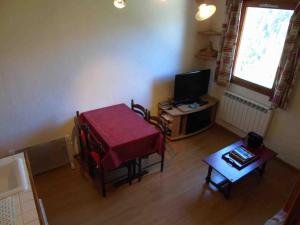 a living room with a table and a television at Appartement Valfréjus, 2 pièces, 4 personnes - FR-1-561-50 in Valfréjus