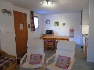 a living room with white chairs and a table at Appartement Valfréjus, 2 pièces, 6 personnes - FR-1-561-80 in Valfréjus