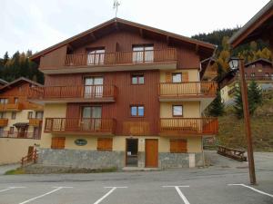 a large apartment building with balconies and a parking lot at Appartement Valfréjus, 4 pièces, 8 personnes - FR-1-561-27 in Valfréjus
