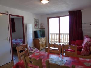 - un salon avec une table, des chaises et une télévision dans l'établissement Appartement Valfréjus, 3 pièces, 6 personnes - FR-1-561-28, à Valfréjus