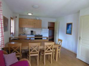 a kitchen and dining room with a wooden table and chairs at Appartement 3P 8 pers. à Valfréjus, balcon ouest, proche télécabine et commerces 조 - FR-1-561-59 in Valfréjus