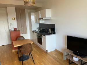 une petite cuisine avec une petite table et une télévision dans l'établissement Appartement Aix-les-Bains, 2 pièces, 2 personnes - FR-1-617-44, à Aix-les-Bains