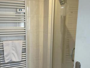 La salle de bains est pourvue d'une douche et d'une serviette blanche. dans l'établissement Appartement Aix-les-Bains, 2 pièces, 2 personnes - FR-1-617-44, à Aix-les-Bains