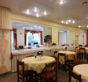 uma sala de jantar com mesas e cadeiras com flores em Hotel Corallo em Giulianova