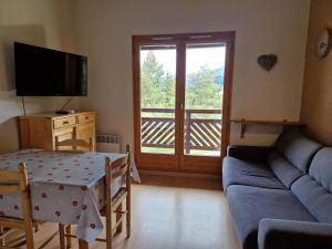 a living room with a couch and a table and a television at Studio La Plagne Montalbert , 1 pièce, 4 personnes - FR-1-755-3 in Aime-La Plagne