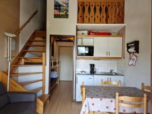 a small kitchen with a table and a staircase in a room at Studio La Plagne Montalbert , 1 pièce, 4 personnes - FR-1-755-3 in Aime-La Plagne