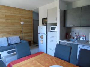 uma cozinha com uma mesa e cadeiras azuis num quarto em Appartement Modane, 3 pièces, 6 personnes - FR-1-561-110 em Modane