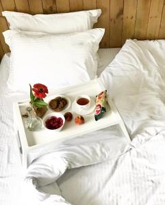 a tray with food and drinks on a bed at Sadyba DarKa in Ternopilʼ