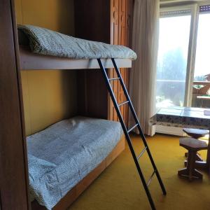 a bunk bed with a ladder in a room with a window at Bellevue Crans-Montana in Crans-Montana